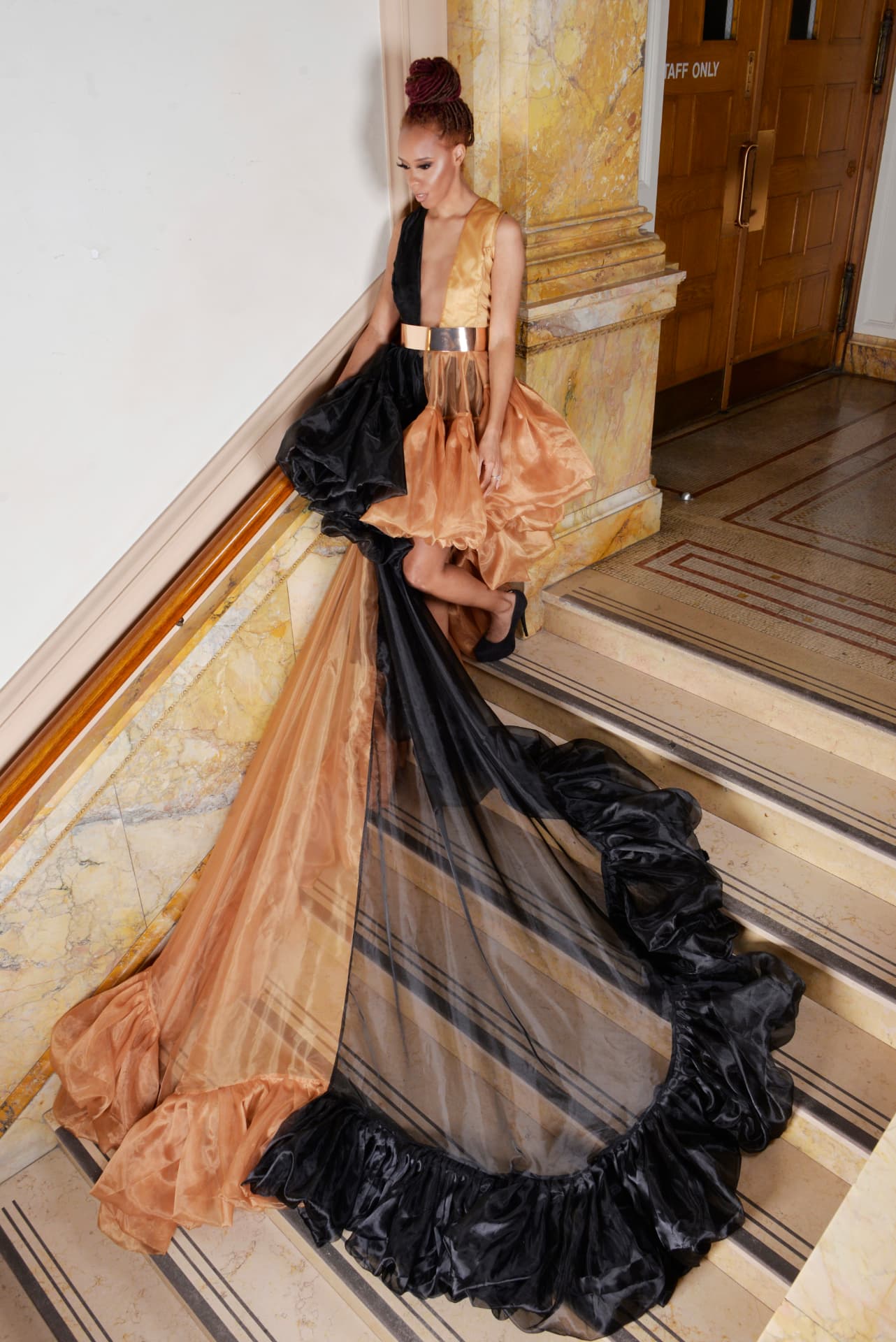 Black and copper organza gown with a gold belt and ruffled train